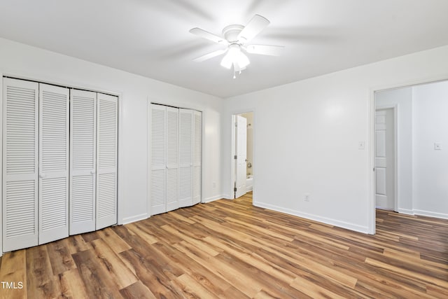 1321 Dylan Heath Ct, Raleigh, NC 27608 - unfurnished bedroom featuring multiple closets, light wood-type flooring, and a ceiling fan