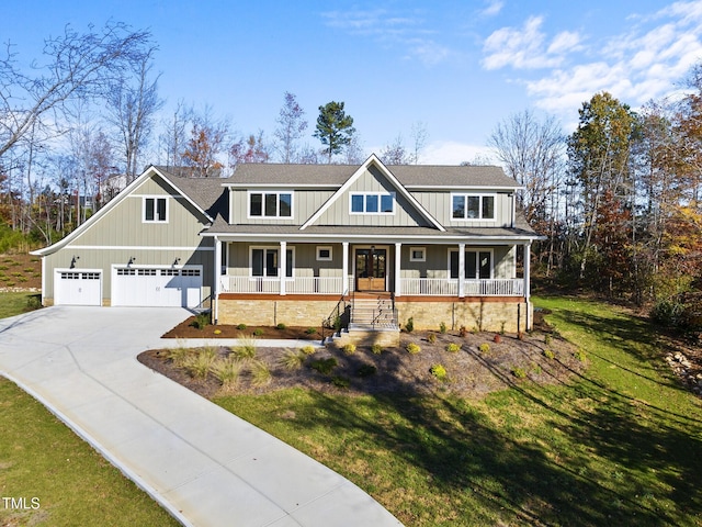 view of front of home with a garage, covered porch, and a front lawn