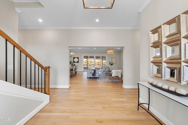 entrance foyer with crown molding, a notable chandelier, and light wood-type flooring