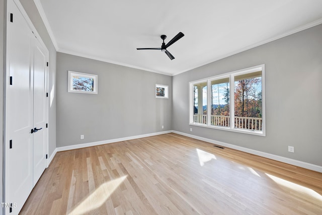 unfurnished bedroom featuring light hardwood / wood-style floors, ceiling fan, and crown molding