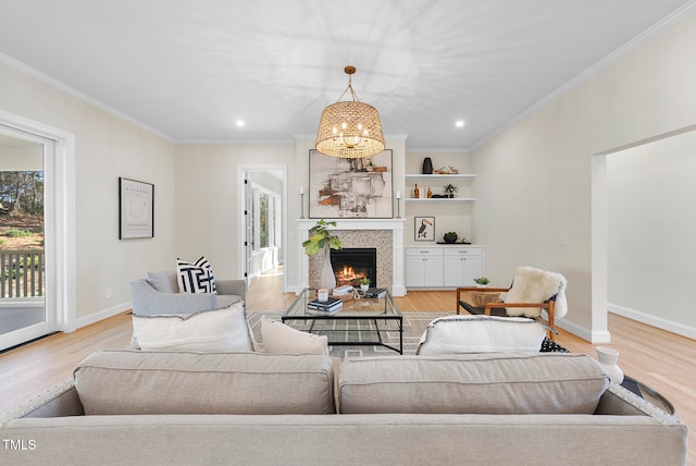 living room with a chandelier, light hardwood / wood-style floors, and ornamental molding