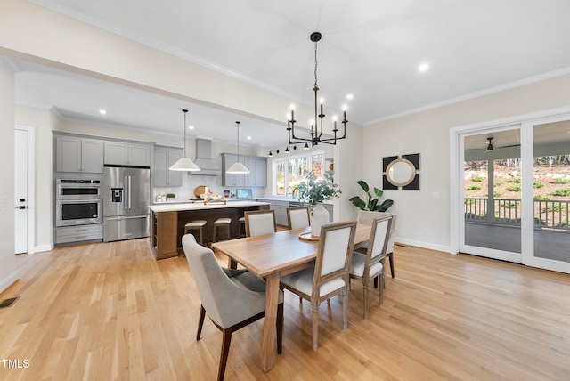 dining room featuring light hardwood / wood-style flooring, an inviting chandelier, and ornamental molding