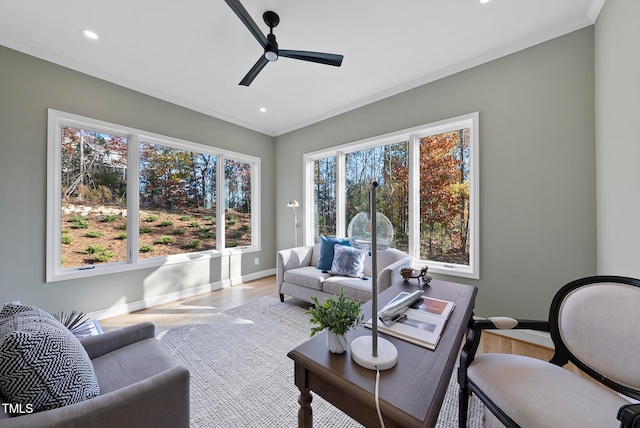 living room with light wood-type flooring, ceiling fan, and ornamental molding