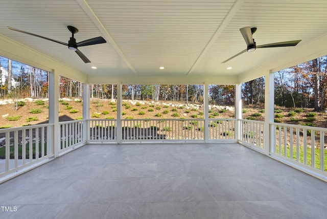 unfurnished sunroom featuring ceiling fan and a healthy amount of sunlight