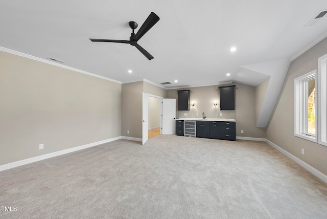 unfurnished living room with carpet, ceiling fan, ornamental molding, and sink