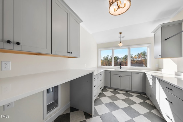 kitchen featuring gray cabinetry, crown molding, sink, and hanging light fixtures