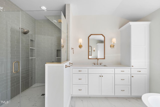 bathroom with a shower with door and vanity