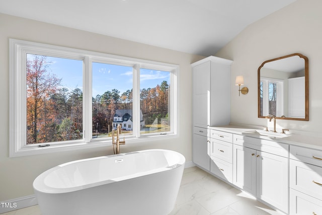 bathroom with vanity, a tub to relax in, and lofted ceiling