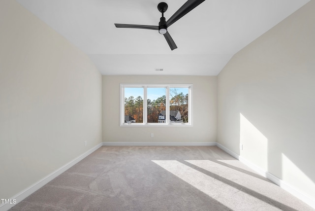 carpeted spare room featuring ceiling fan and lofted ceiling