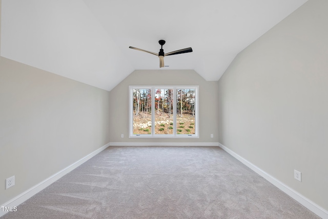 interior space featuring ceiling fan, light carpet, and vaulted ceiling