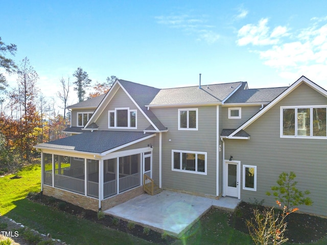 rear view of property with a yard, a patio, and a sunroom