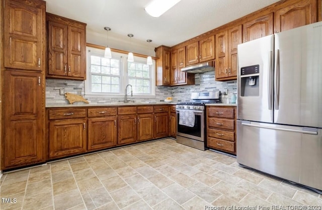 kitchen with backsplash, hanging light fixtures, stainless steel appliances, and sink