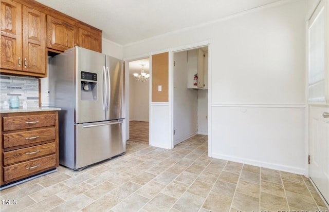 kitchen with stainless steel fridge, backsplash, and a notable chandelier