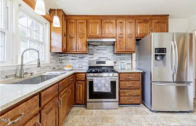 kitchen with light stone countertops, sink, hanging light fixtures, tasteful backsplash, and appliances with stainless steel finishes