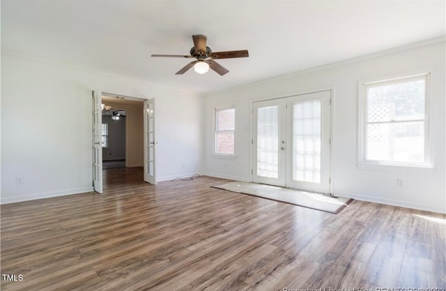 empty room with french doors, dark hardwood / wood-style floors, plenty of natural light, and ceiling fan