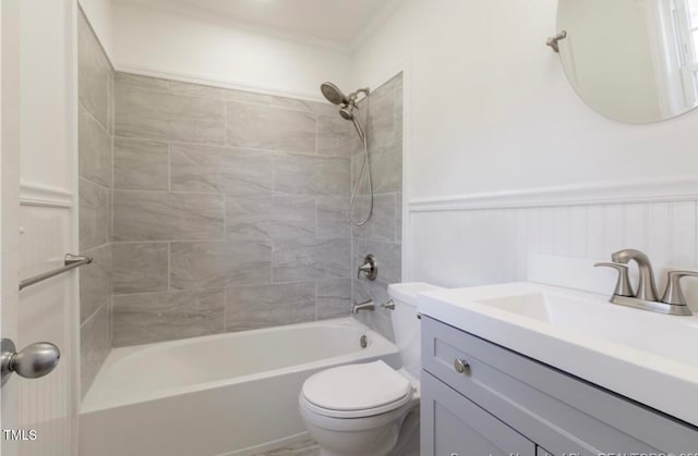 full bathroom with vanity, toilet, tiled shower / bath, and ornamental molding