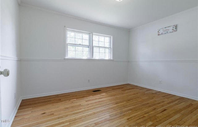 unfurnished room featuring crown molding and light wood-type flooring