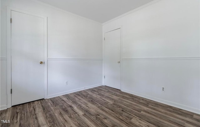 empty room featuring dark hardwood / wood-style flooring and crown molding