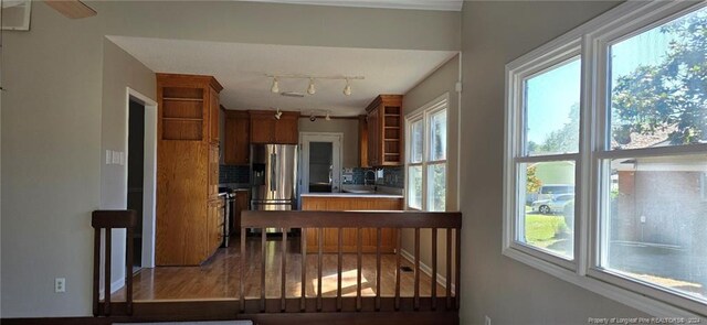 kitchen with stainless steel refrigerator with ice dispenser, backsplash, and wood-type flooring