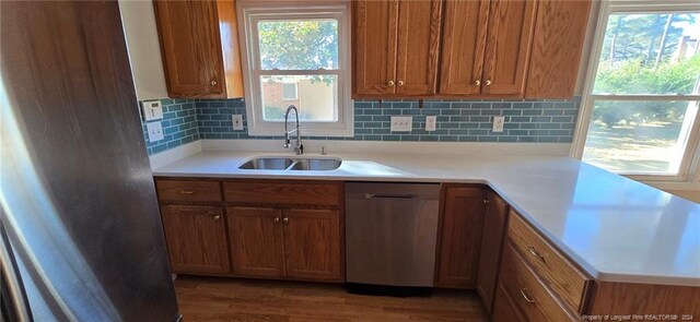 kitchen with tasteful backsplash, dark hardwood / wood-style flooring, sink, and stainless steel dishwasher