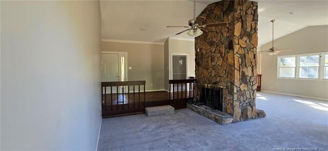 carpeted living room with ceiling fan, a stone fireplace, ornamental molding, and high vaulted ceiling