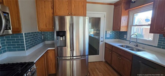 kitchen with decorative backsplash, a wealth of natural light, sink, and appliances with stainless steel finishes