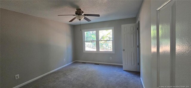 spare room with carpet flooring, ceiling fan, and a textured ceiling