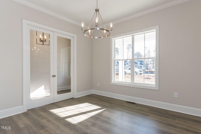 empty room with dark wood-style floors, ornamental molding, and an inviting chandelier