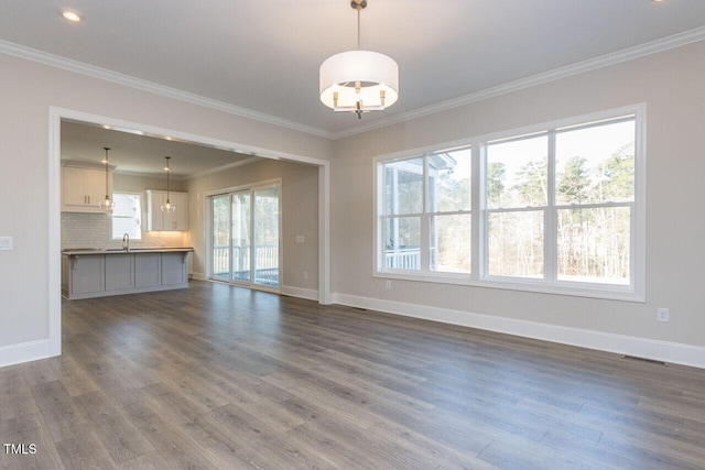 unfurnished living room with dark wood-style floors, a sink, and baseboards