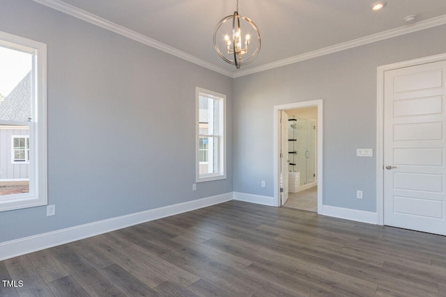 unfurnished room featuring a notable chandelier, ornamental molding, dark wood finished floors, and baseboards