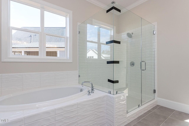 bathroom featuring baseboards, ornamental molding, tile patterned flooring, a shower stall, and a bath