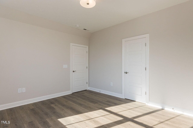 unfurnished room with wood finished floors and baseboards