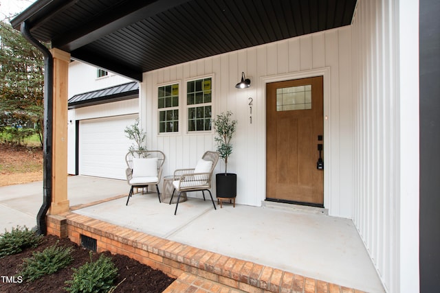 property entrance featuring covered porch and a garage