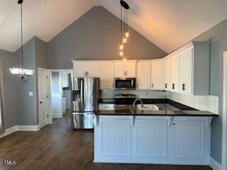 kitchen featuring dark wood-type flooring, white cabinets, stainless steel appliances, and decorative light fixtures