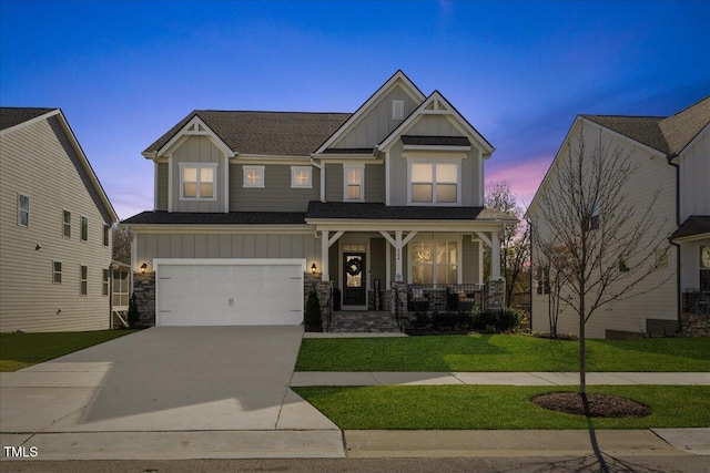 craftsman-style house featuring a lawn, covered porch, and a garage