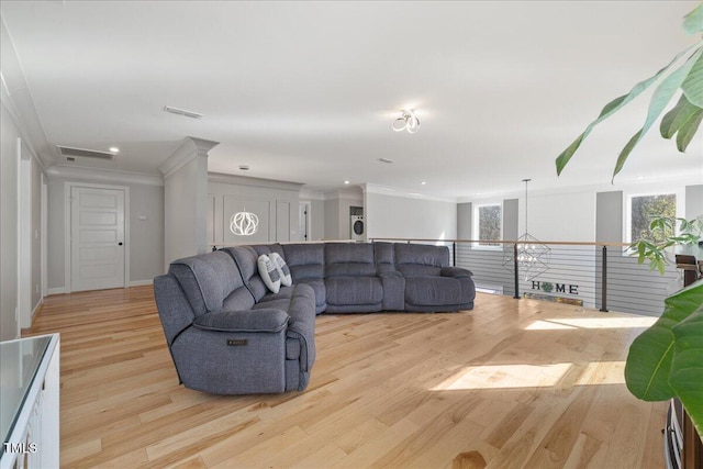 living room featuring an inviting chandelier, light hardwood / wood-style floors, and ornamental molding