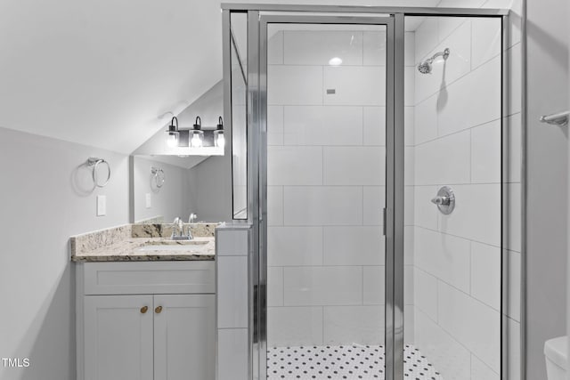 bathroom featuring vanity, toilet, lofted ceiling, and walk in shower