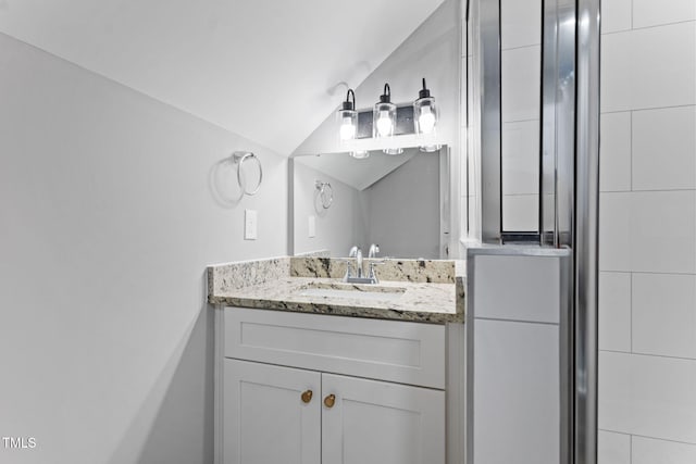 bathroom featuring vanity, lofted ceiling, and walk in shower