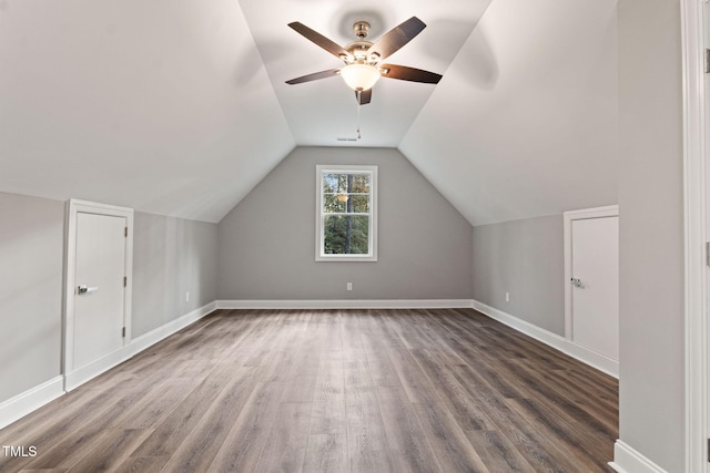 additional living space featuring dark hardwood / wood-style floors, vaulted ceiling, and ceiling fan