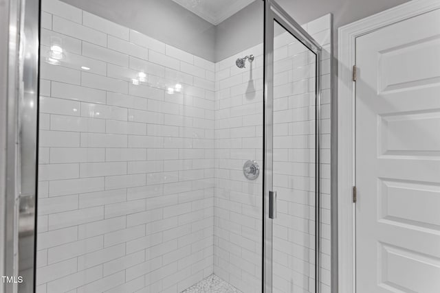 bathroom featuring crown molding and a shower with shower door