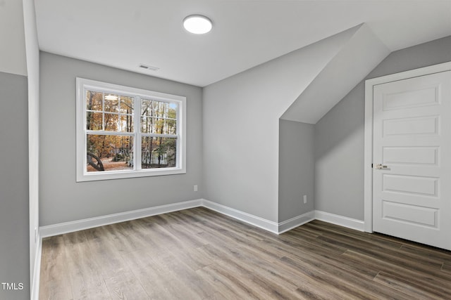 bonus room with wood-type flooring and lofted ceiling