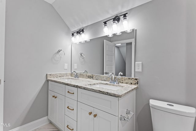 bathroom with vanity, toilet, and vaulted ceiling