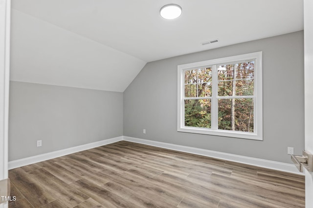 bonus room with wood-type flooring and vaulted ceiling