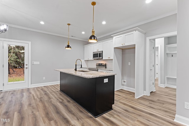 kitchen featuring white cabinetry, sink, light stone countertops, hanging light fixtures, and appliances with stainless steel finishes