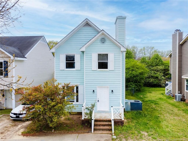 view of front of home featuring central AC unit and a front yard