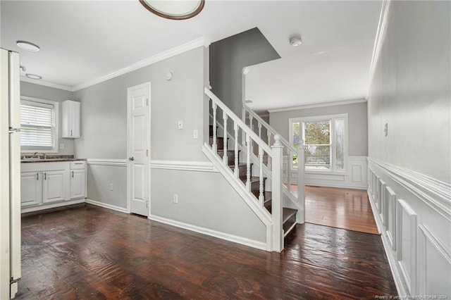 stairway featuring hardwood / wood-style flooring, sink, and crown molding