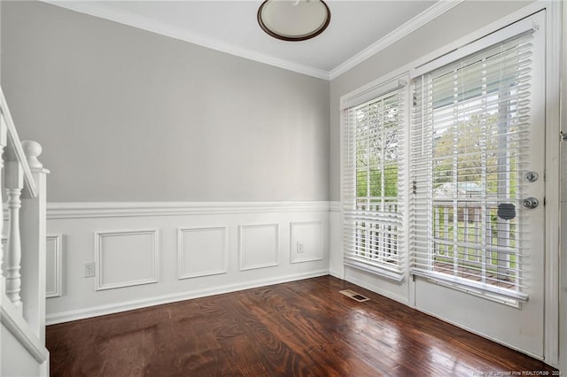 empty room with a healthy amount of sunlight, ornamental molding, and dark wood-type flooring