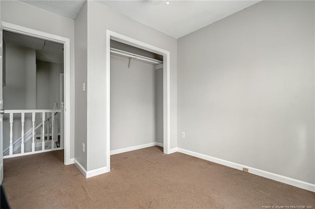 unfurnished bedroom featuring a closet, carpet, and a textured ceiling