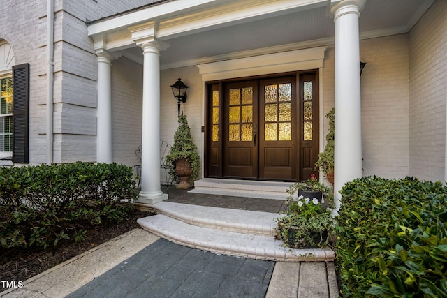 view of exterior entry with a porch and french doors