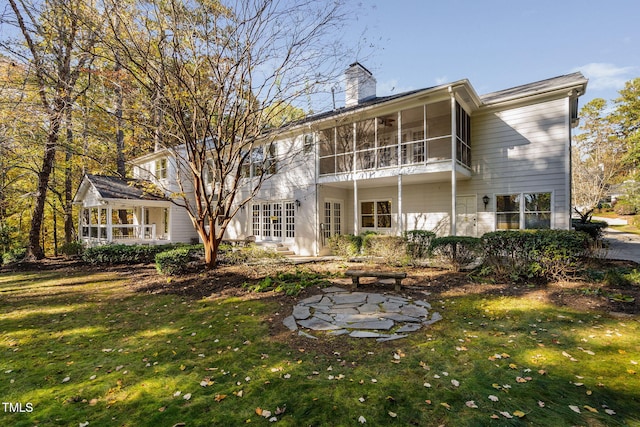 back of house with a sunroom and a lawn